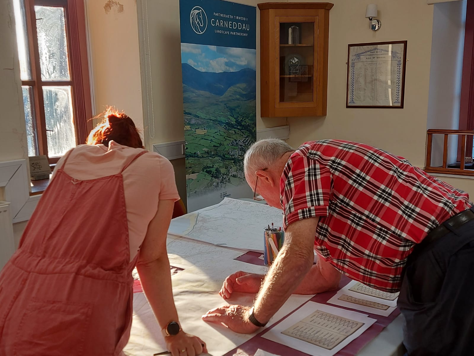 Carneddau Research Officer with a volunteer inspecting the map for local place names
